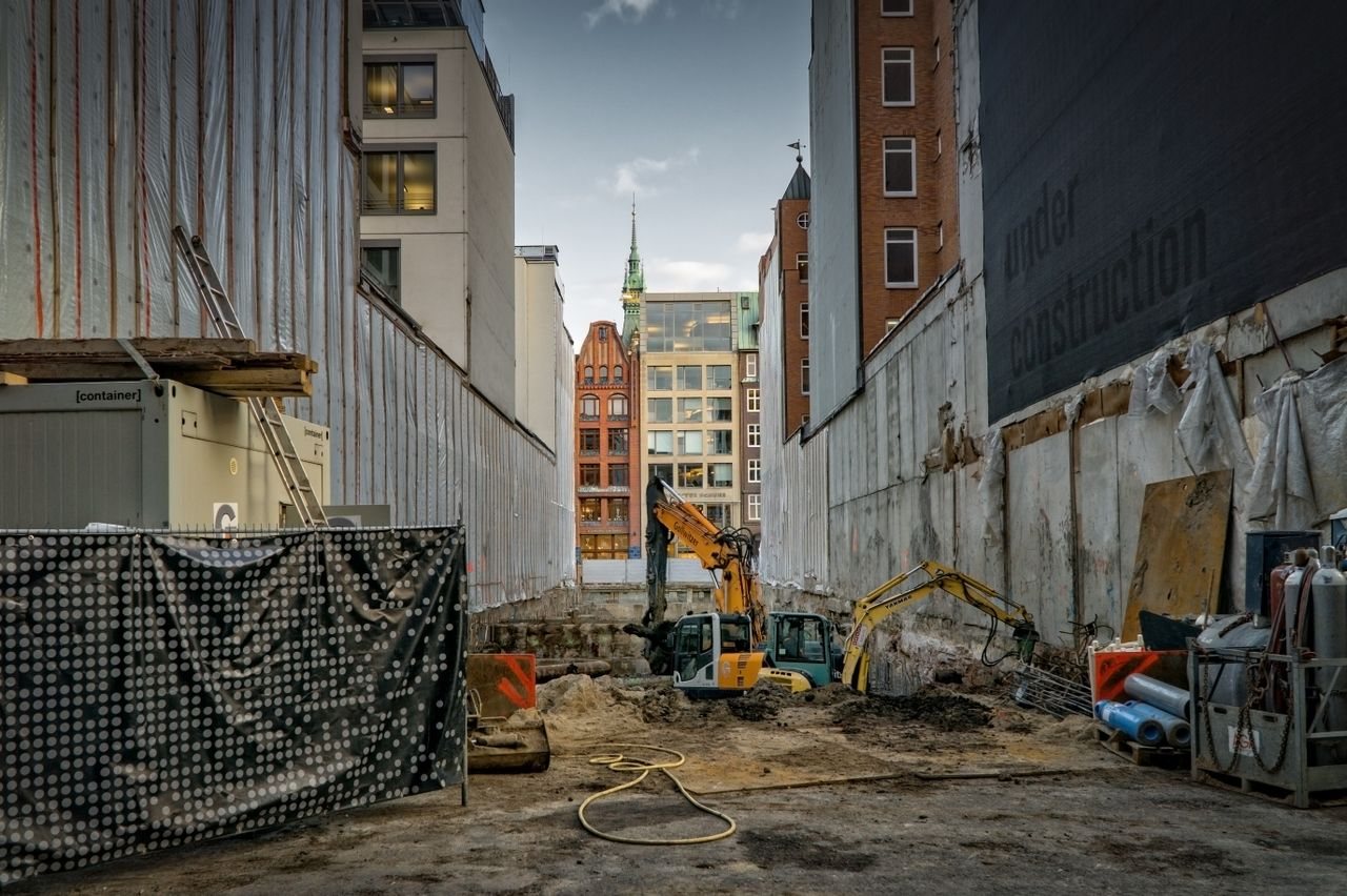Free Construction site in an urban area with excavators and scaffolding, showcasing development. Stock Photo