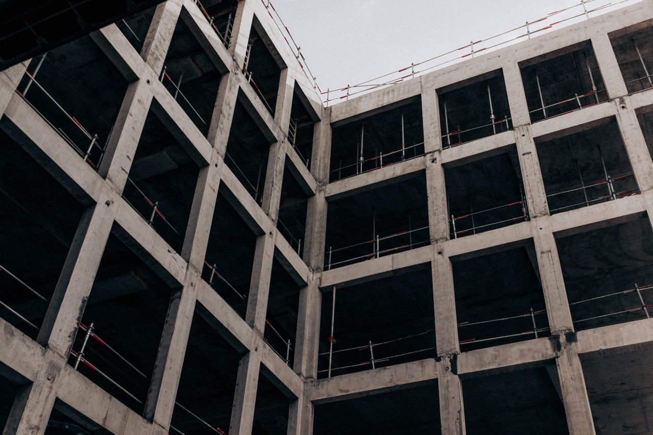 Free A low angle view of a modern concrete building under construction, showcasing its structure and design. Stock Photo